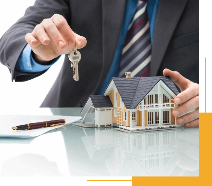 A Man Holding a House Key in Front of a Model House