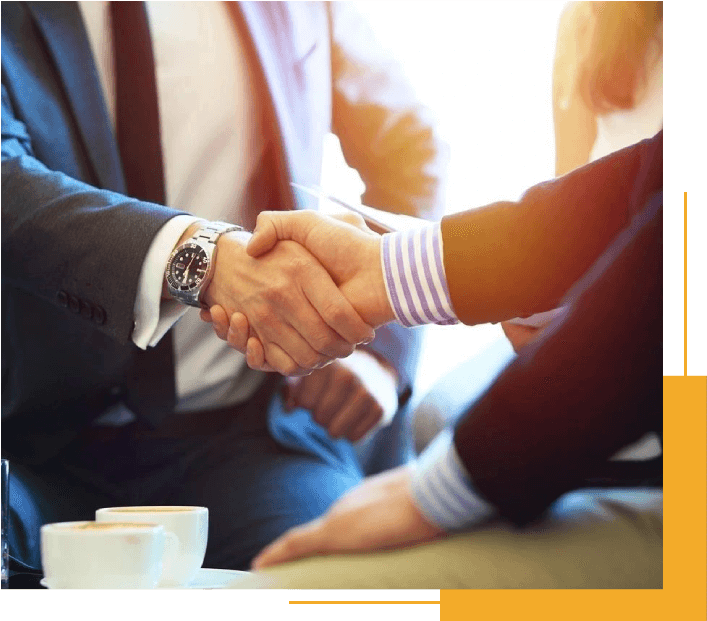 Two People Shaking Hands Over a Cup of Coffee