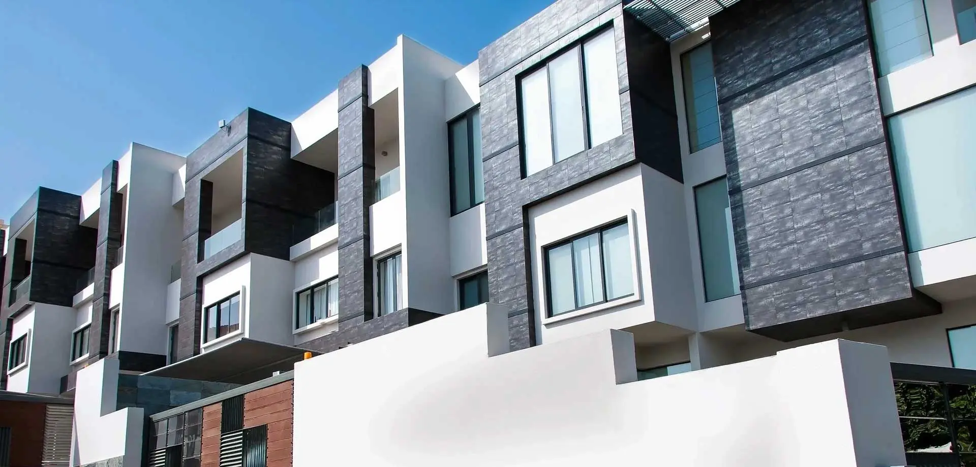 A Row of Multi - Story Apartment Buildings on a Sunny Day